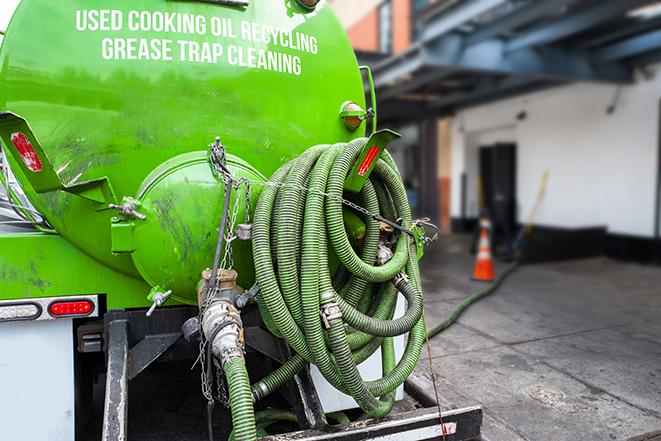 a technician pumping a grease trap in a commercial building in Perris, CA